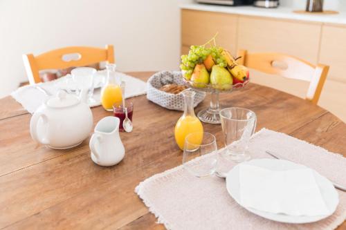 una mesa de madera con un bol de fruta y zumo en Les Chambres du Méteil, en Mazé