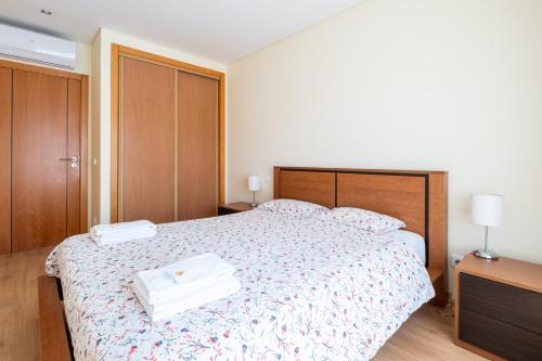 a bedroom with a bed with two towels on it at Casa da Praia in São Martinho do Porto
