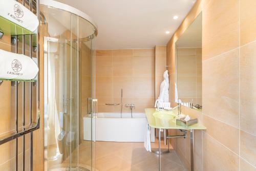 a bathroom with a tub and a sink and a shower at Il Boscareto Resort & Spa in Serralunga d'Alba
