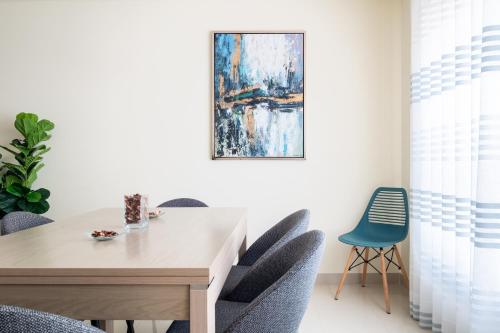 a dining room table with chairs and a painting on the wall at Casa da Praia in São Martinho do Porto
