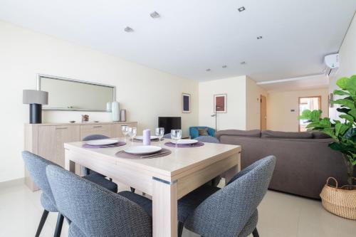 a dining room and living room with a table and chairs at Casa da Praia in São Martinho do Porto
