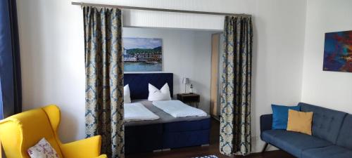 a bedroom with a blue bed and a couch at Hotel Zur Fähre in Boppard