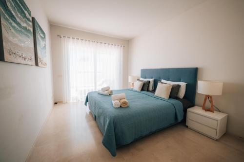 a bedroom with a blue bed and a window at Luxury Penthouse Alcazaba Lagoon 521 - EHHouse in Estepona
