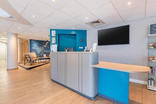 an office lobby with a counter and a tv at Appart'City Confort Montpellier Saint Roch in Montpellier