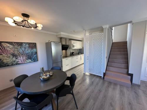Una sala de estar con una mesa y una escalera. en SANTA ANA 8, en Maspalomas