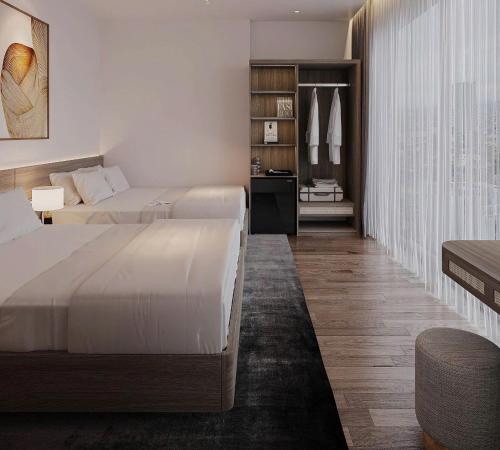 a hotel room with two beds and a closet at Sunrise Hotel Thiên Cầm in Ha Tinh