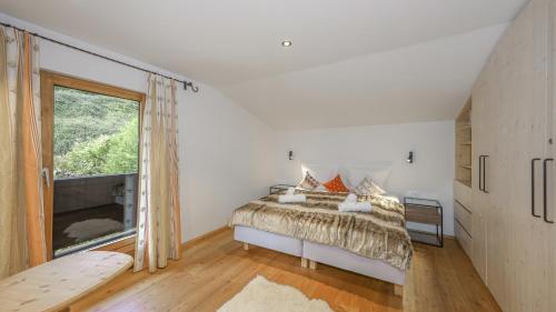 a bedroom with a bed and a large window at Chalet Moralee Kitzbühel, Whirlpool & Alpenblick in Kitzbühel