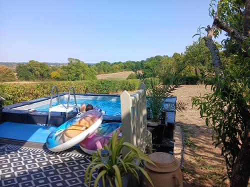 a child in a raft in a swimming pool at Cidre Bois in Saint-Sulpice-le-Dunois