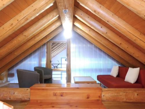a living room with wooden ceilings and a red couch at Holiday Home Rustico dell'Orino by Interhome in Alpe di Scieru