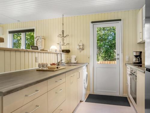 a kitchen with white cabinets and a white door at Holiday Home Gunhil - 200m from the sea by Interhome in Hals