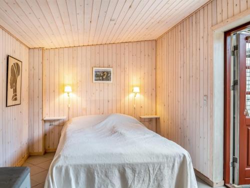 a bedroom with a bed in a wooden wall at Holiday Home Gunhil - 200m from the sea by Interhome in Hals