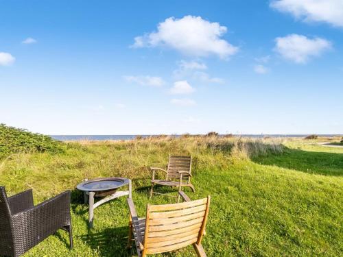 a group of chairs and a table on a field at Holiday Home Agrippa - 30m to the fjord by Interhome in Løgstør