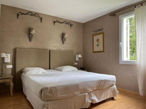 a bedroom with a large bed and a window at Logis Hôtel restaurant des Pins in Bédoin