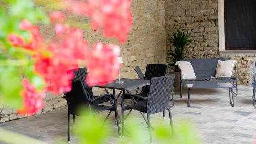 a table and chairs on a patio with pink flowers at Ca' Ginet in Cravanzana