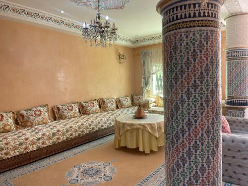 a living room with a long couch and a table at silia wifi fibre optique 200 Mé gratuit in Fès