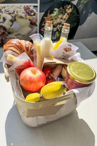 a basket of food with apples and fruit and drinks at Apartment Siófok by Interhome in Balatonszemes