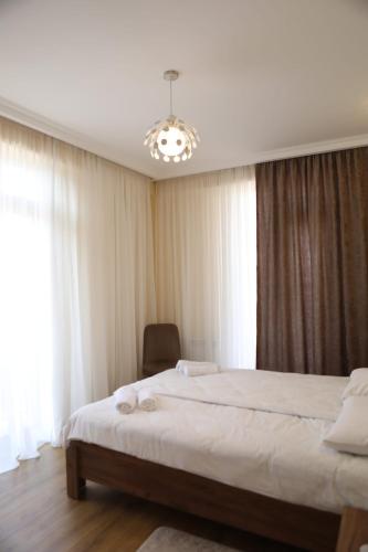 a bedroom with two beds and a chandelier at Stylish House in Kutaisi