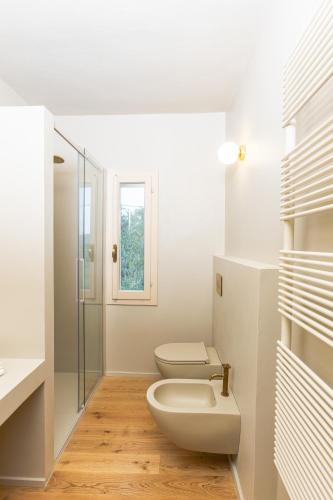 a bathroom with a toilet and a glass shower at Castello di Ribano Le Dimore in Savignano sul Rubicone
