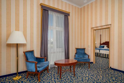 a room with two chairs and a table and a lamp at Ensana Grand Margaret Island in Budapest
