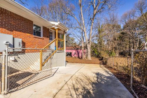 a house with a gate and a fence at Cozy Apartment, Mins To Airport in Forest Park