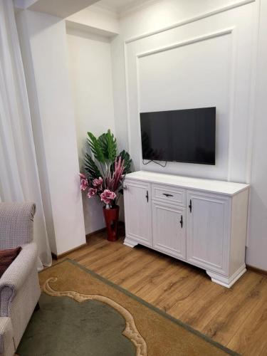 a living room with a television on a white cabinet at Stylish House in Kutaisi