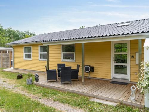 a yellow house with a wooden deck at Holiday Home Barth - 950m from the sea by Interhome in Vig