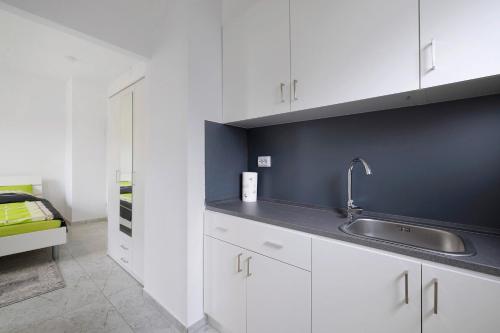 a kitchen with white cabinets and a sink at Haus Rosa in Albstadt