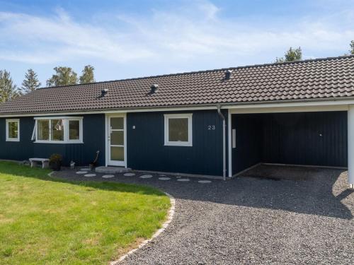 a blue house with a garage at Holiday Home Asvalde - 200m to the inlet by Interhome in Vordingborg
