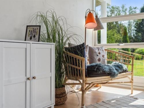 a living room with a chair and a window at Holiday Home Asvalde - 200m to the inlet by Interhome in Vordingborg