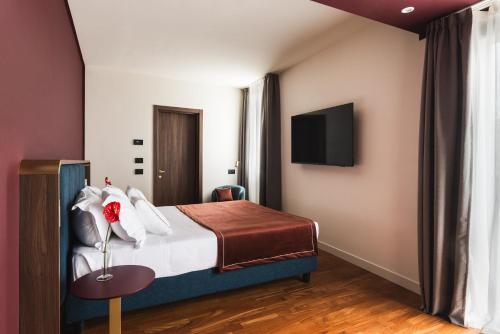 a hotel room with a bed and a tv at Casa D'Este - Hotel Ferrara in Ferrara