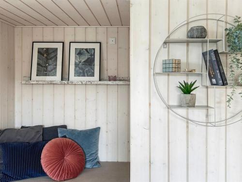 a living room with a couch and a red pillow at Holiday Home Enisa - 800m from the sea by Interhome in Åkirkeby