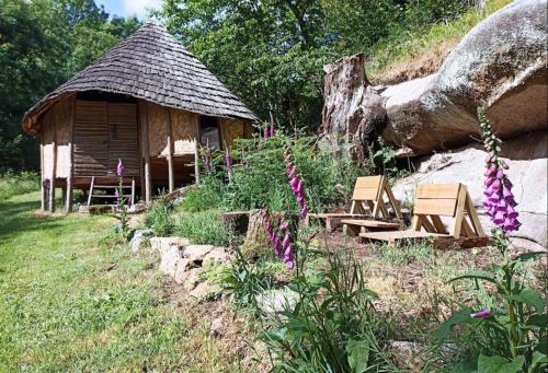 a log cabin with two chairs and a tree at Terragora Lodges - Hébergement atypique in Les Épesses