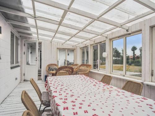 a dining room with a table and chairs on a porch at Holiday Home Janna - 75m from the sea by Interhome in Gørlev