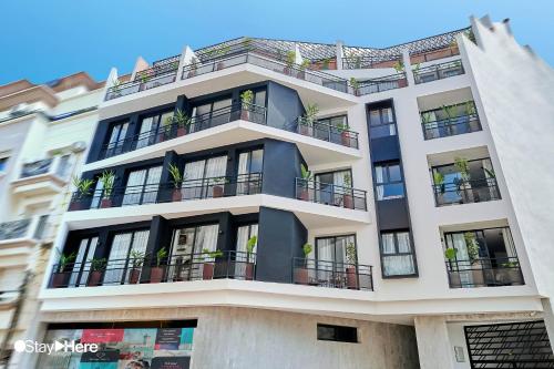 a tall white building with potted plants on the balconies at Stayhere Casablanca - Maarif - Elite Residence in Casablanca