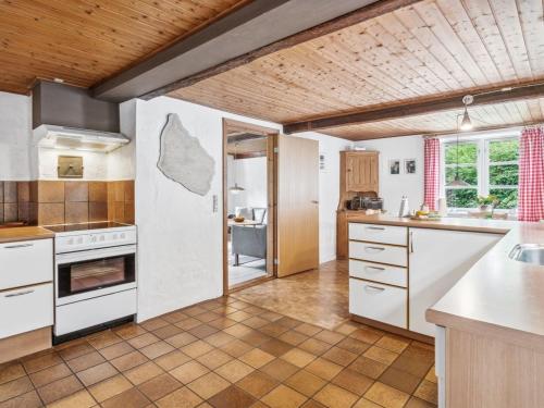 a kitchen with white appliances and a wooden ceiling at Holiday Home Rina - 250m from the sea by Interhome in Hasle