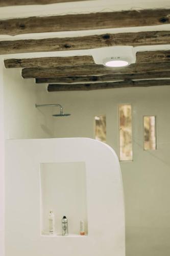 a room with a wooden ceiling and a white refrigerator at Craft House - An Artistic Oasis in Watamu