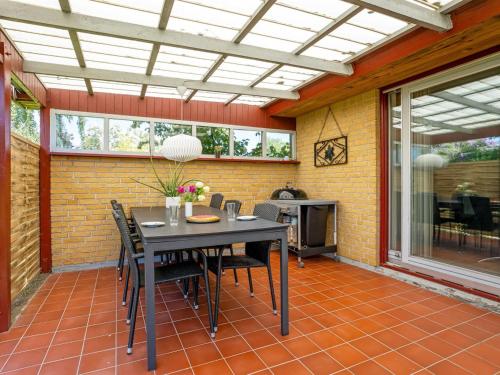 a dining room with a table and chairs on a patio at Holiday Home Maleen - 150m to the inlet by Interhome in Nakskov