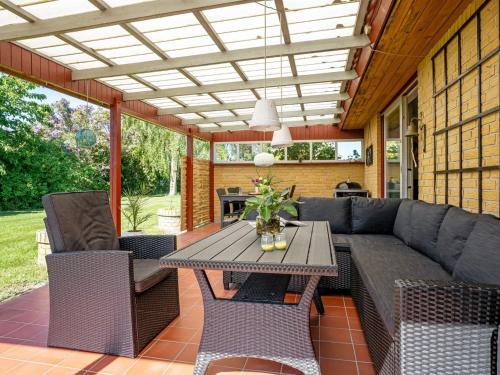 a patio with a couch and a table and chairs at Holiday Home Maleen - 150m to the inlet by Interhome in Nakskov