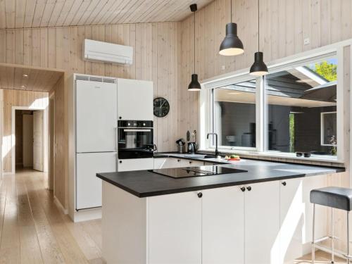 a kitchen with white cabinets and a black counter top at Holiday Home Heidel - 1-1km from the sea by Interhome in Nyrup