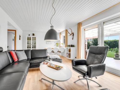 a living room with a black couch and chairs at Holiday Home Maleen - 150m to the inlet by Interhome in Nakskov