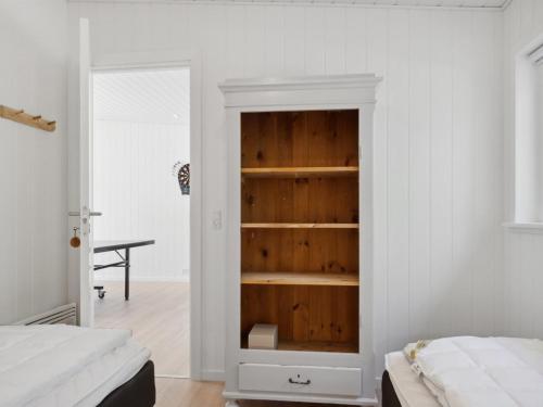 a bedroom with a built in book shelf next to a bed at Holiday Home Tinja - 900m from the sea by Interhome in Højby
