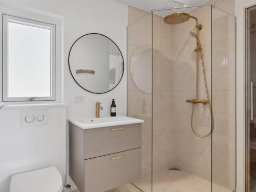 a bathroom with a shower and a sink and a mirror at Holiday Home Tinja - 900m from the sea by Interhome in Højby