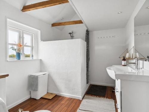 a bathroom with white walls and a sink and a window at Holiday Home Finja - 6km from the sea by Interhome in Horslunde