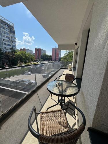a balcony with a table and chairs and a view of a street at Luxury Studios at Unique opposite Palas with Parking in Iaşi