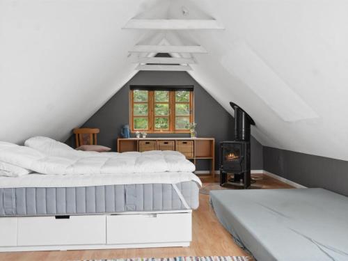 a attic bedroom with two beds and a fireplace at Holiday Home Finja - 6km from the sea by Interhome in Horslunde