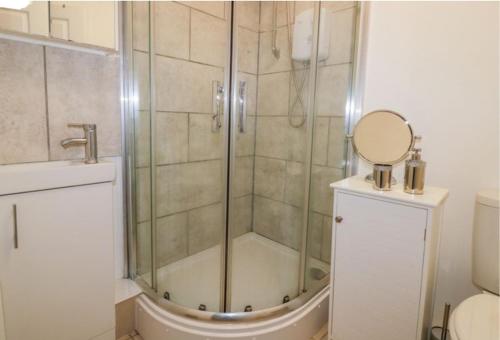 a bathroom with a shower with a sink and a mirror at By the Beach Perranporth, Truro, cornwall in Perranporth