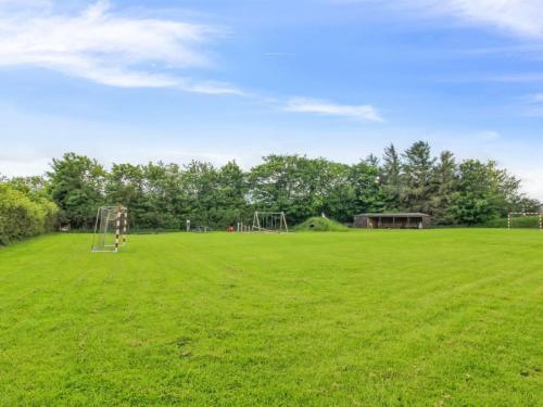 a large grassy field with a playground at Holiday Home Melin - 7km from the sea by Interhome in Højer