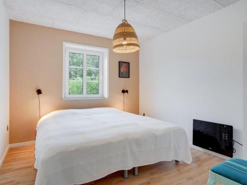 a bedroom with a large white bed and a tv at Holiday Home Melin - 7km from the sea by Interhome in Højer