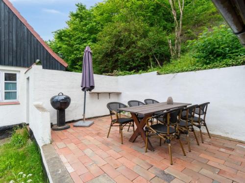 a patio with a table and chairs and an umbrella at Holiday Home Scarlet - 5m from the sea by Interhome in Hasle