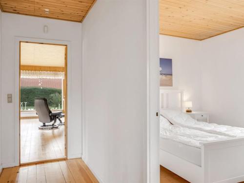 a bedroom with a bed and a desk and a chair at Holiday Home Rikhard - 75m from the sea by Interhome in Dannemare